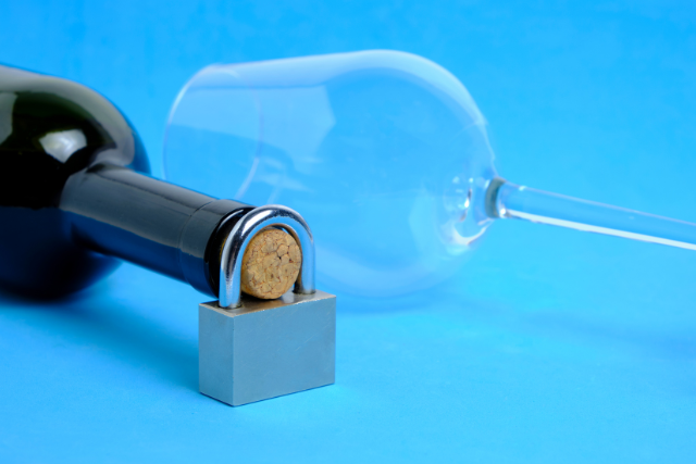 locked bottle of alcohol and empty glass