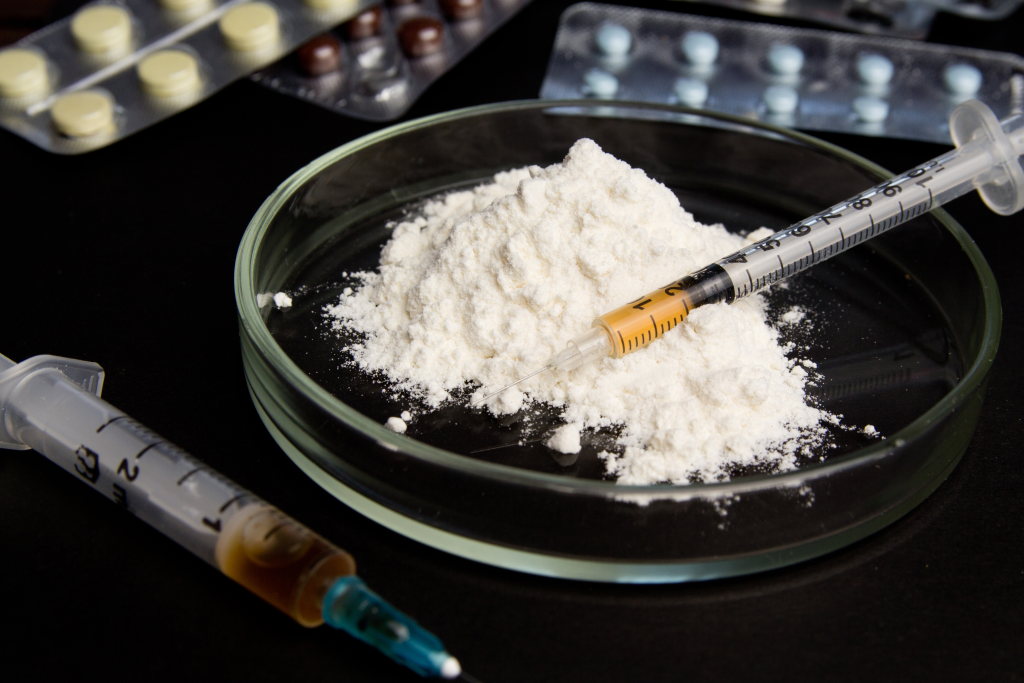 syringe on top of powdered opioid